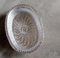 Multipurpose oval silver tray with a royal pattern for various uses.